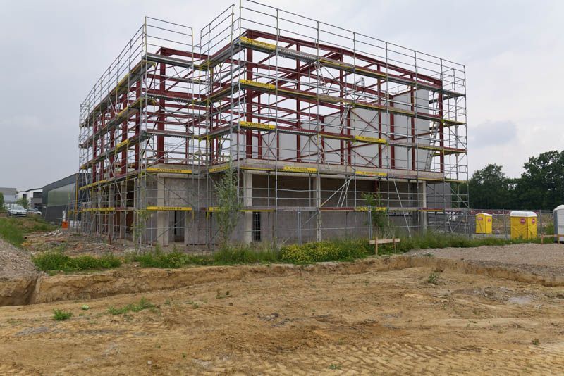 Es wird ein großes Gebäude errichtet, das von einem Gerüst umgeben ist.