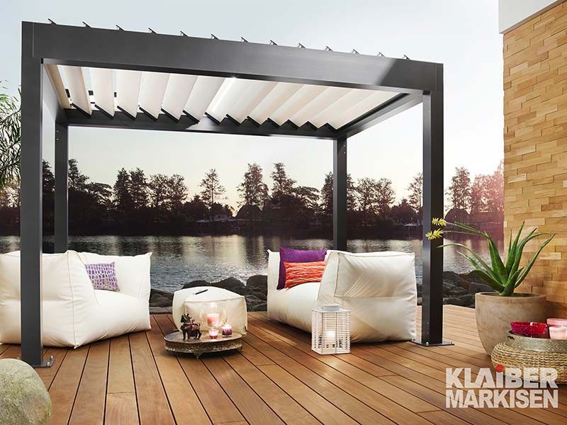 Eine Terrasse mit Pergola und einem See im Hintergrund