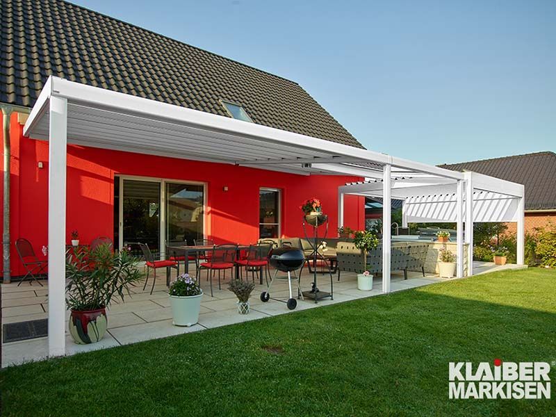 Ein rotes Haus mit einer weißen Pergola davor