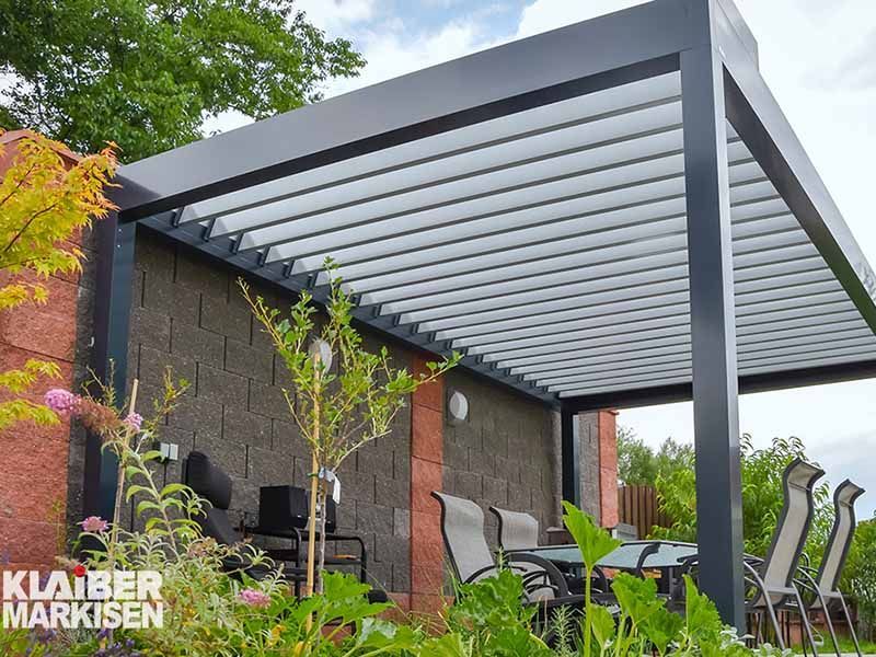 Eine Pergola mit einem Tisch und Stühlen darunter