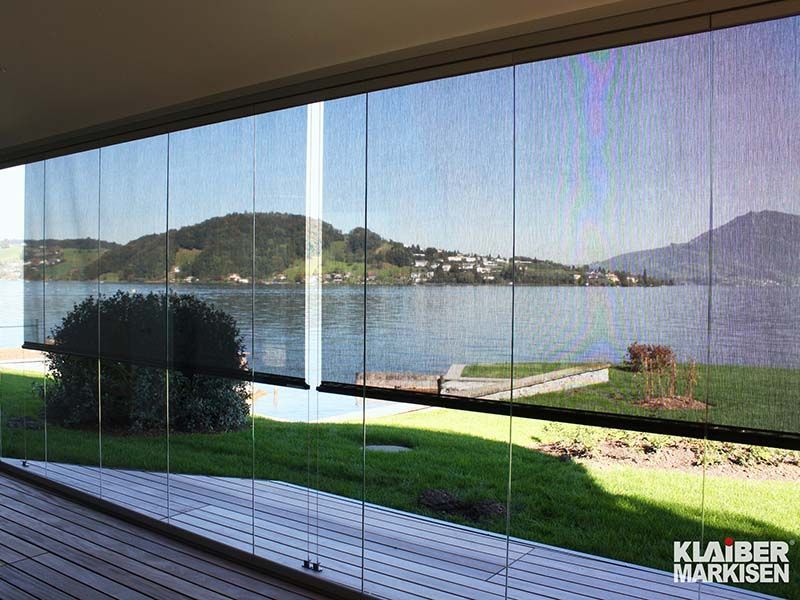 Ein großes Fenster mit Blick auf See und Berge.