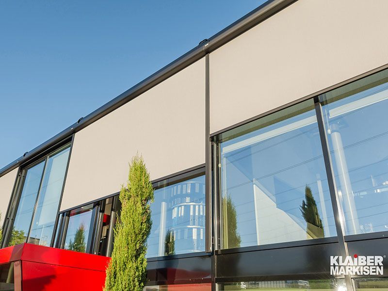 Ein Gebäude mit vielen Fenstern und einem Schild mit der Aufschrift „Kiaber Markisen“