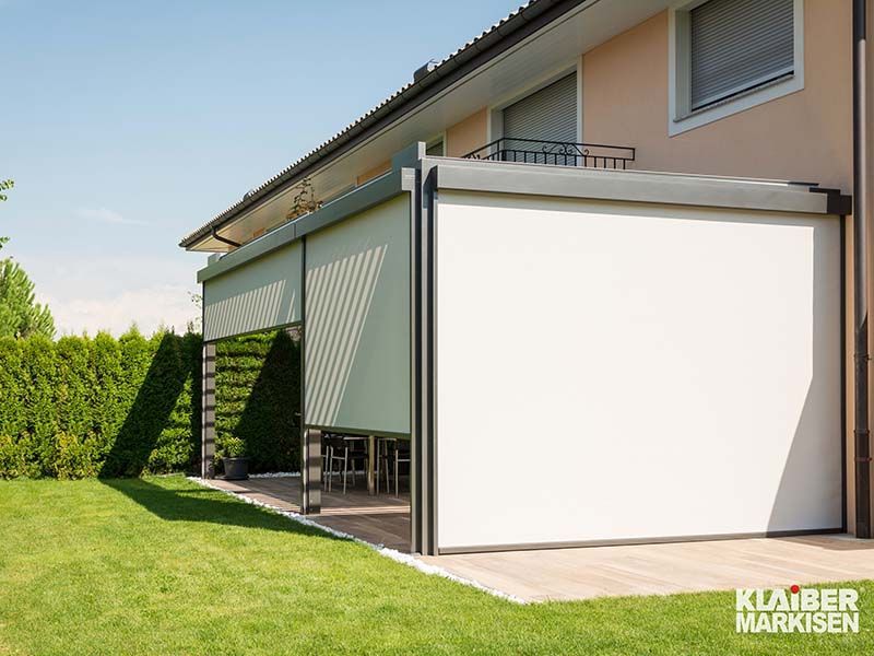 Ein Haus mit einem großen weißen Bildschirm an der Seite.