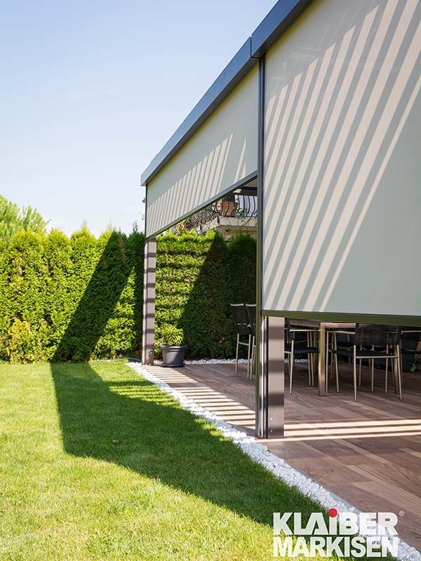 Eine Terrasse mit Tisch und Stühlen unter einem Baldachin.