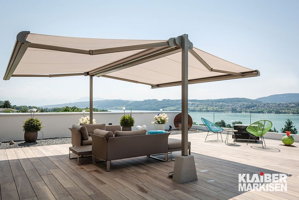 Eine Terrasse mit Sofa und Stühlen unter einer Markise.