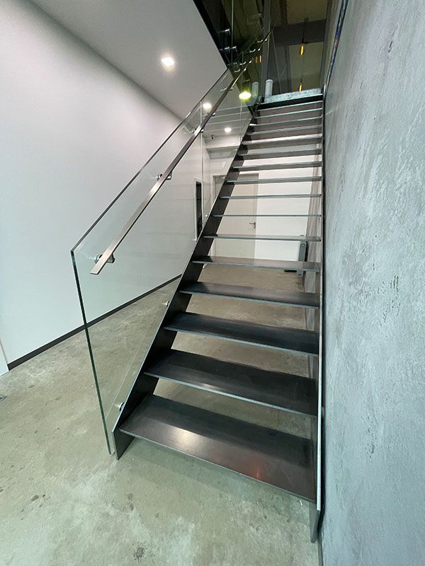 Eine Treppe mit einem Glasgeländer in einem Gebäude.