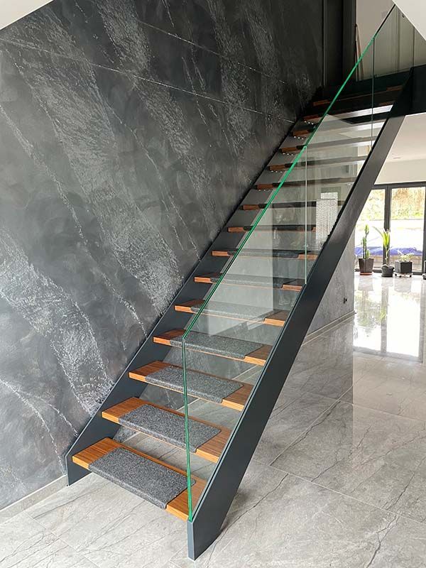 Eine moderne Treppe mit Holzstufen und einem Glasgeländer.