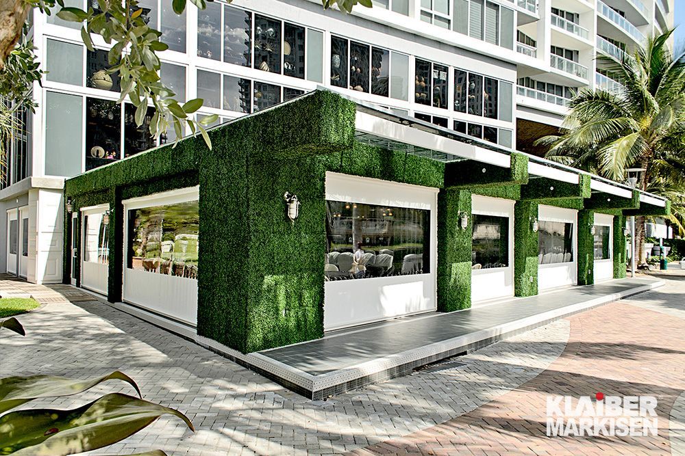 Ein Gebäude mit vielen Fenstern und einer grünen Wand.