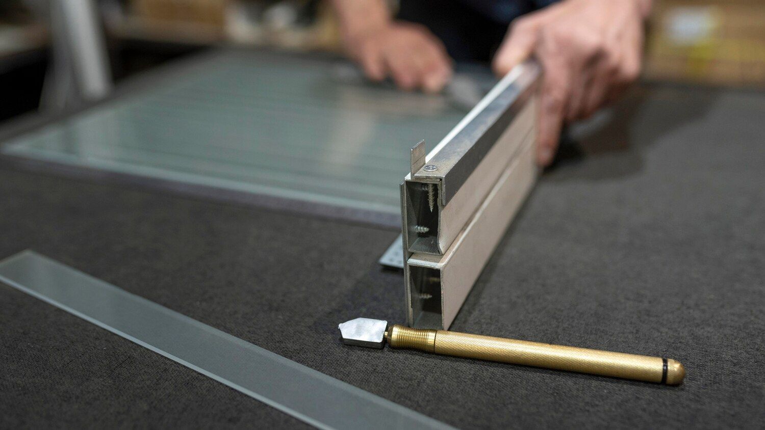 Sobre una mesa, junto a un trozo de vidrio y una barra metálica de soporte