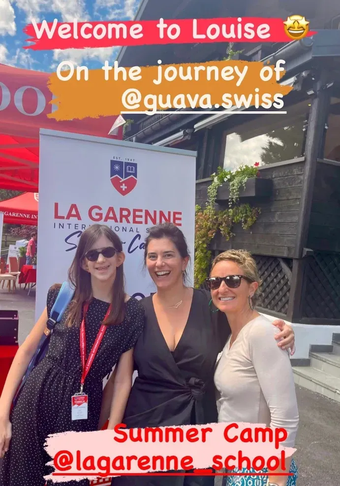 Trois femmes posent devant une banderole d'école. Texte : Bienvenue à Louise, colonie de vacances