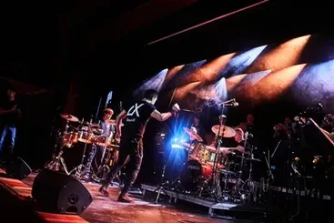 Groupe se produisant sur scène avec des projecteurs.