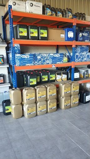 Un almacén lleno de muchas botellas de aceite y baterías.