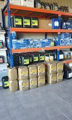 Un almacén lleno de muchas botellas de aceite y baterías.