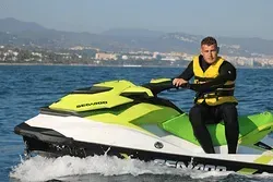 Dos personas viajan en una moto acuática en el océano.