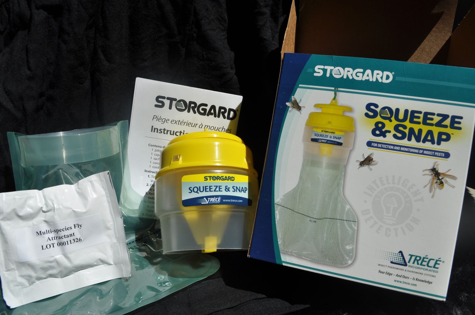 Composants du piège à mouches Storgard Squeeze & Snap : sachet d’appât, récipient et instructions.
