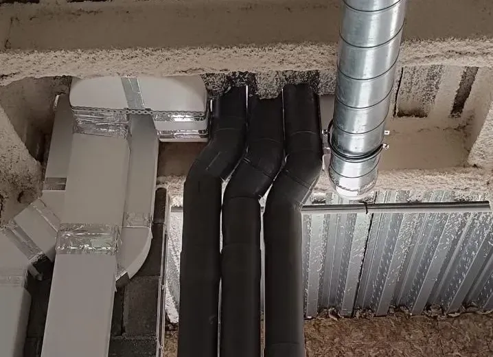 Vista de las tuberías expuestas del edificio y de los conductos rectangulares de climatización.