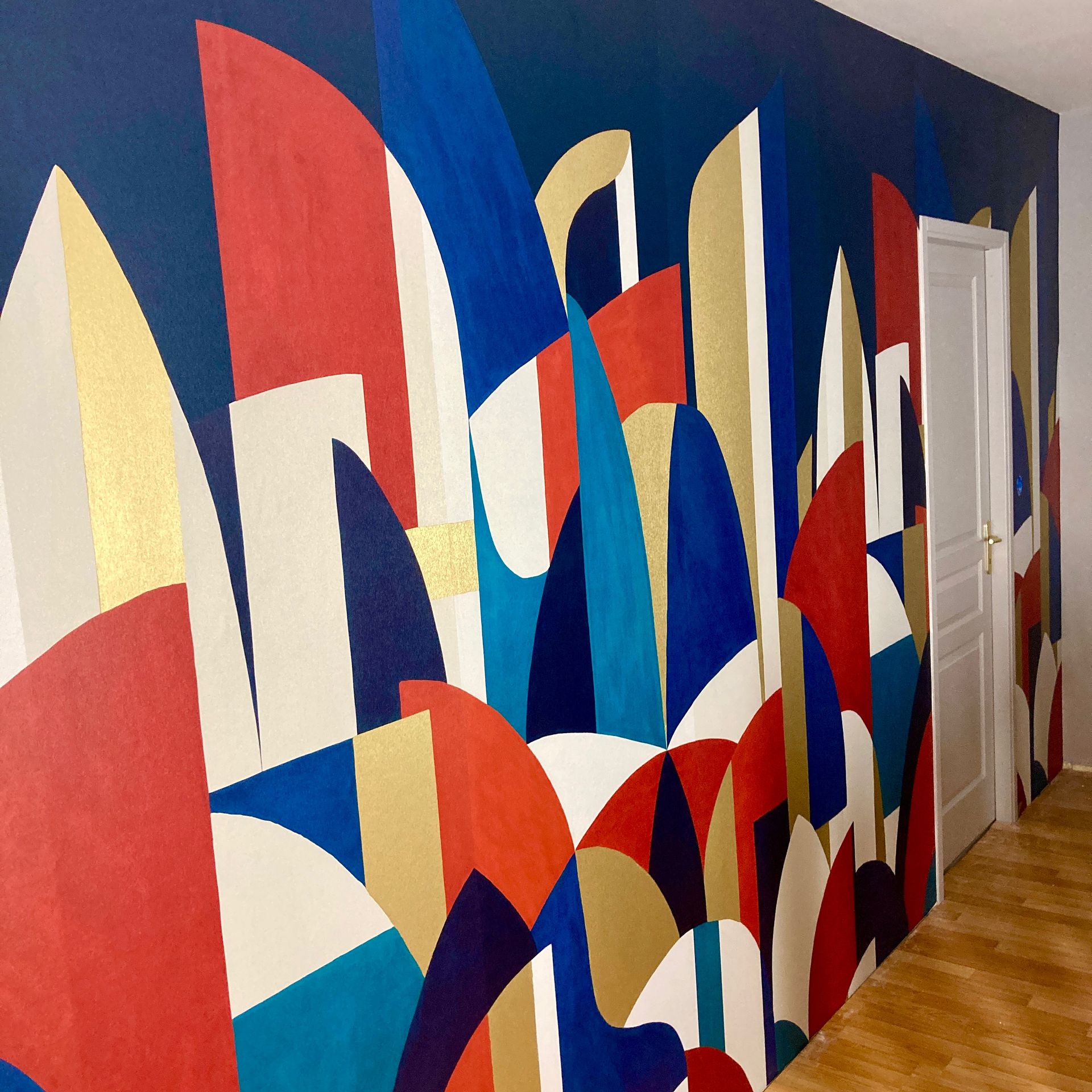 Fresque abstraite aux tons rouges, bleus, dorés et blancs.