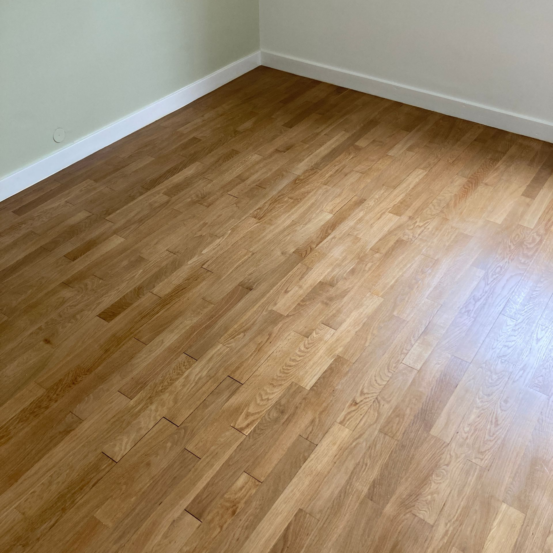 Sol en bois dans une pièce aux murs clairs.