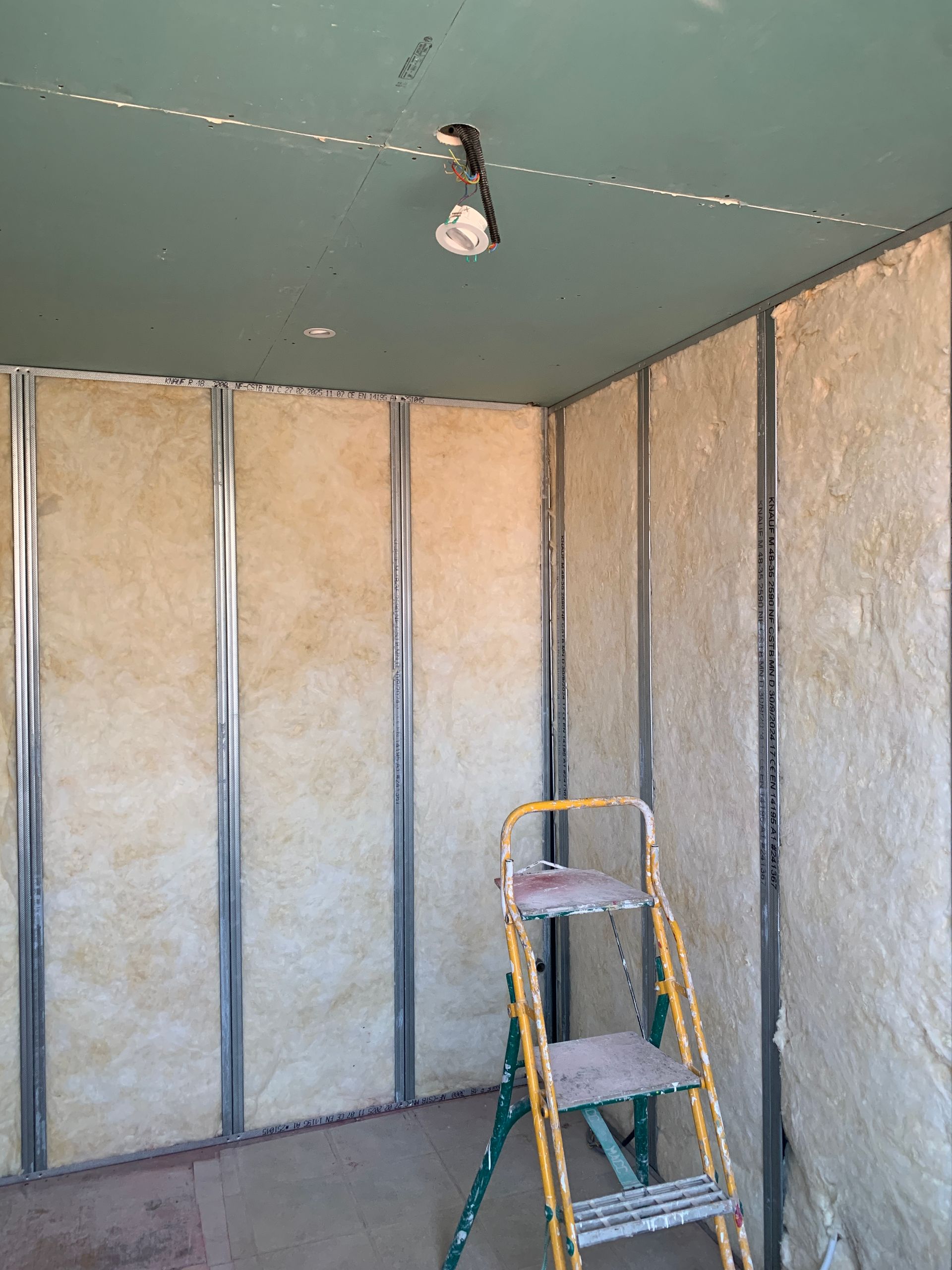 Pièce avec ossature métallique, isolation et cloisons sèches.