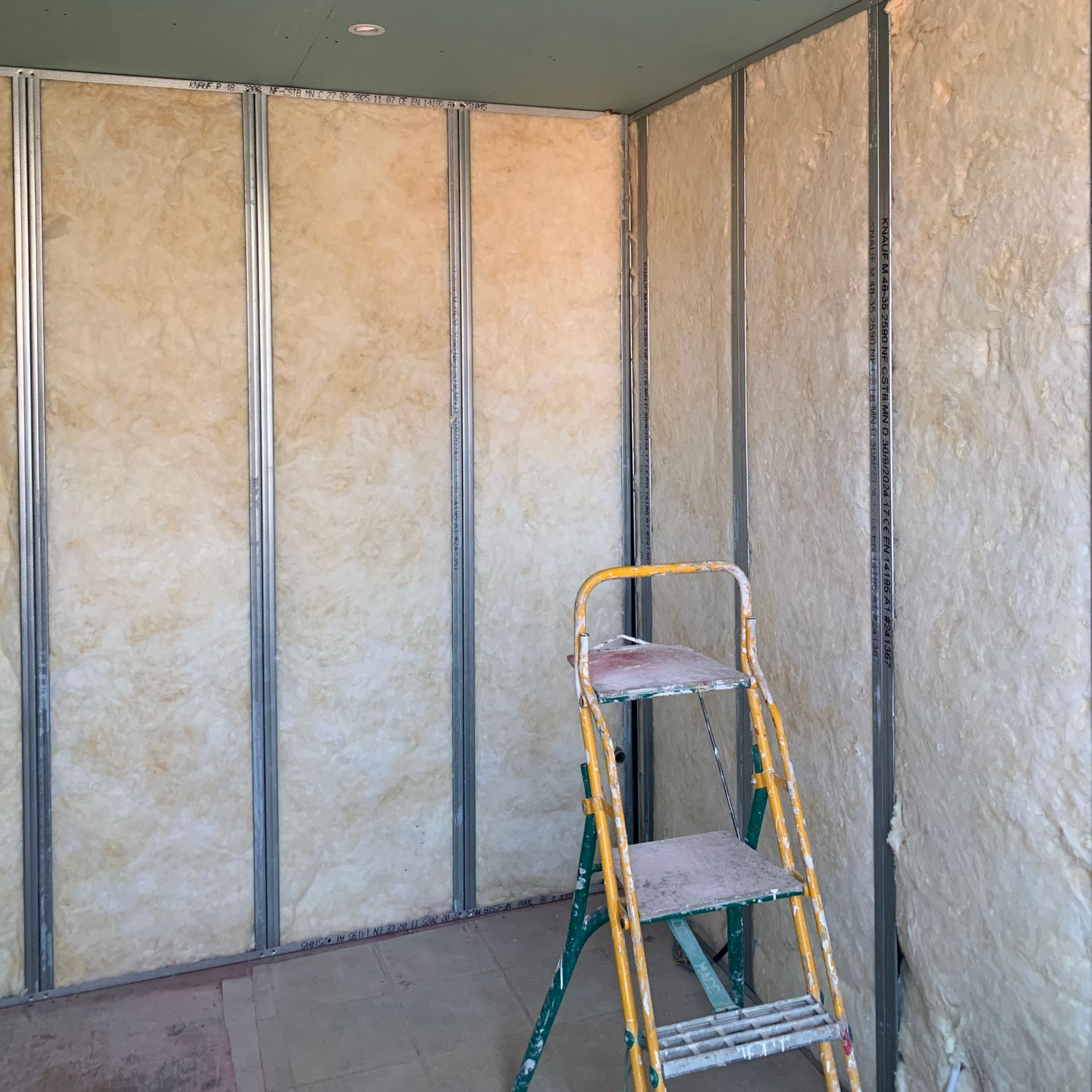 Ossature intérieure d'une pièce avec isolation entre les montants métalliques.