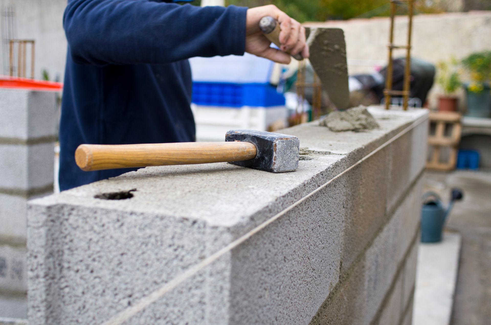 Un maçon qui construit un mur de parpaings