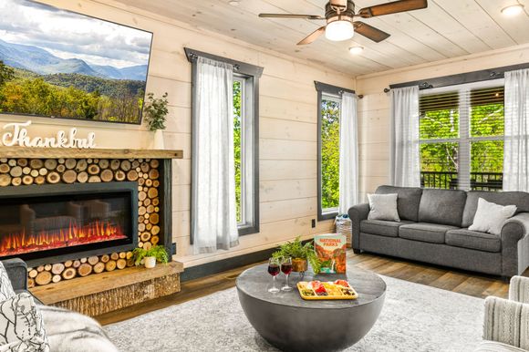 A living room with a fireplace , couch , coffee table and television.