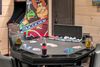 A poker table with a coca cola bottle on it in a game room.