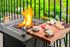 A fire pit with s'mores and crackers on a cutting board on a balcony.