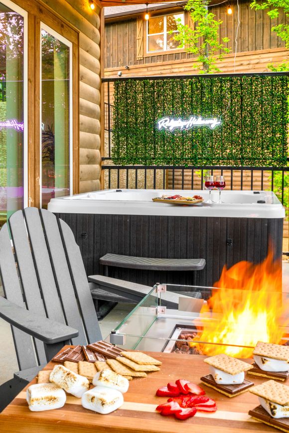 A hot tub is sitting next to a table with s'mores and crackers on it.