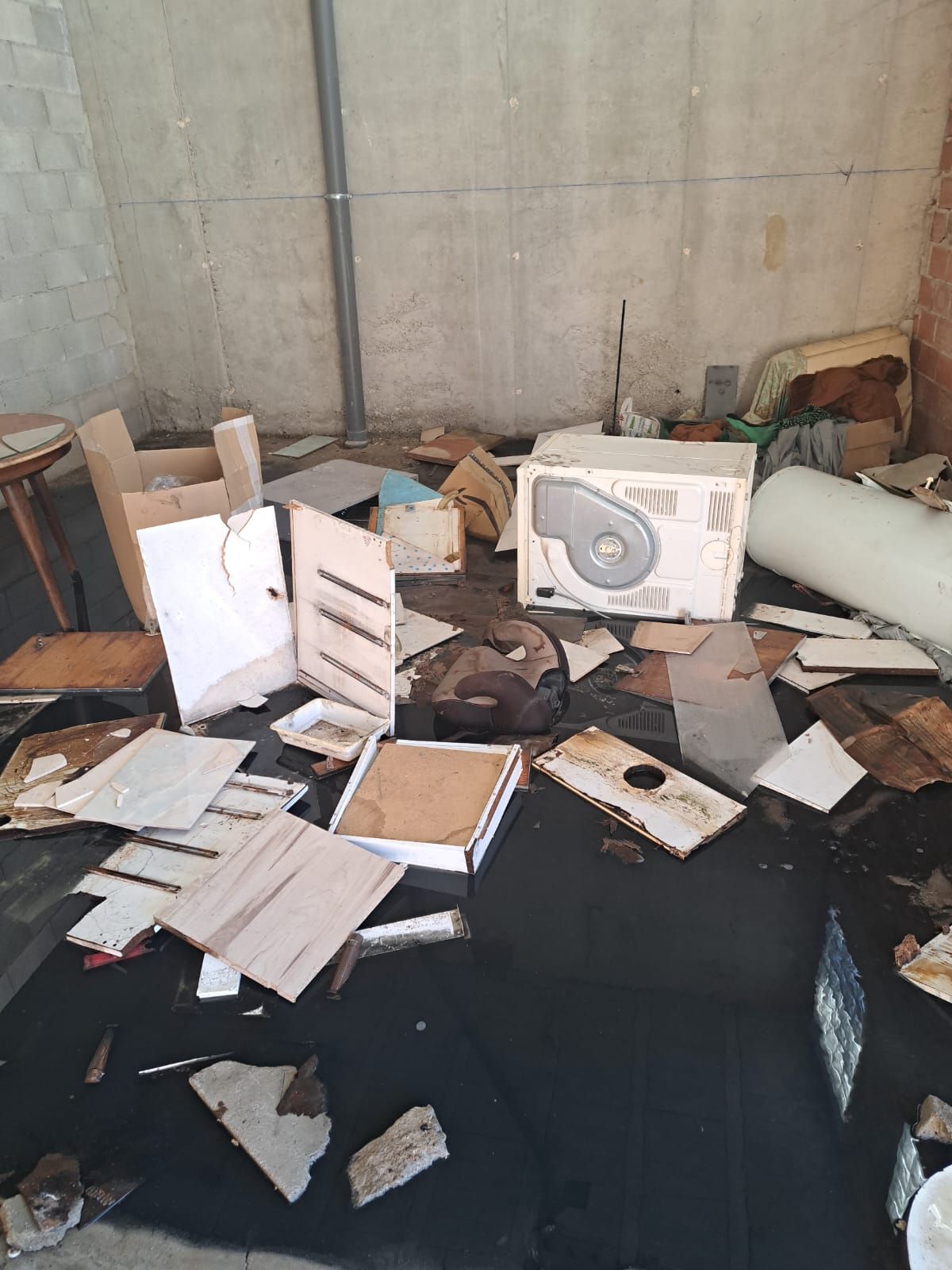 Una habitación desordenada con una caja de ventilador en el suelo.