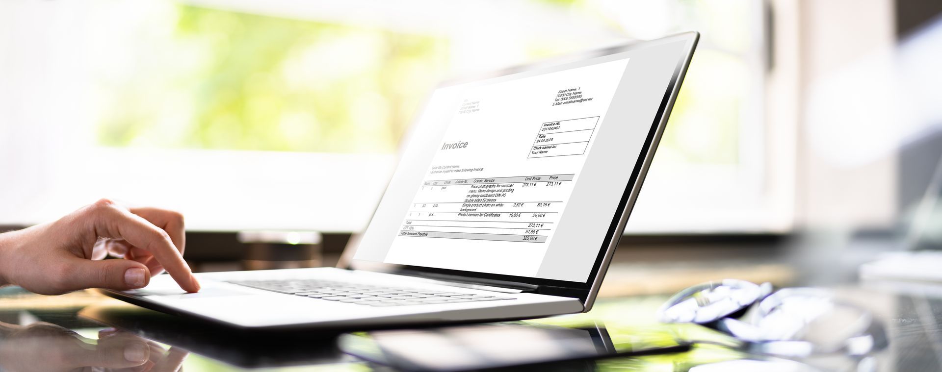 Une personne tape sur un ordinateur portable dans un bureau lumineux, un document étant ouvert à l'écran.