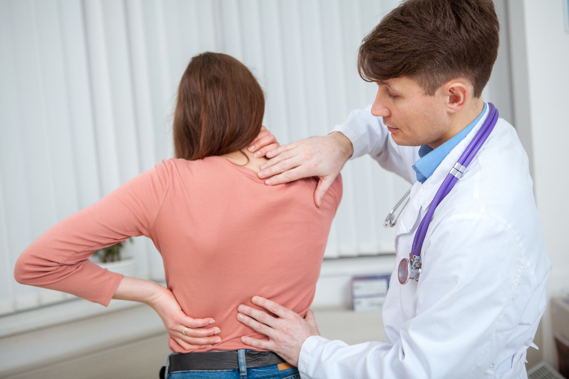 Chiropraticien auscultant le dos d'une femme