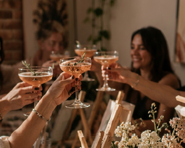 Amigos brindando con copas de champán en una cena a la luz de las velas.