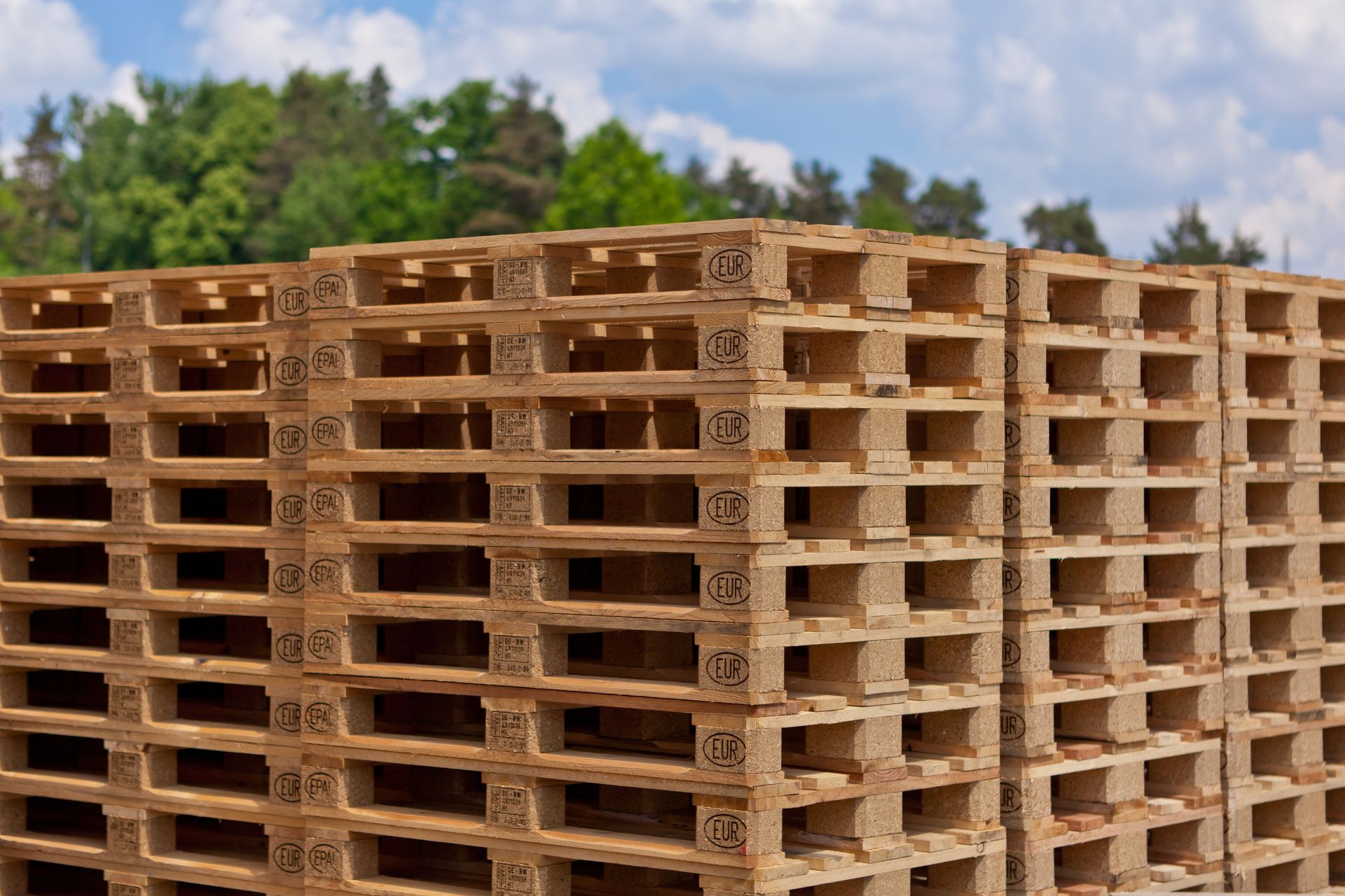 Piles de palettes en bois en extérieur.