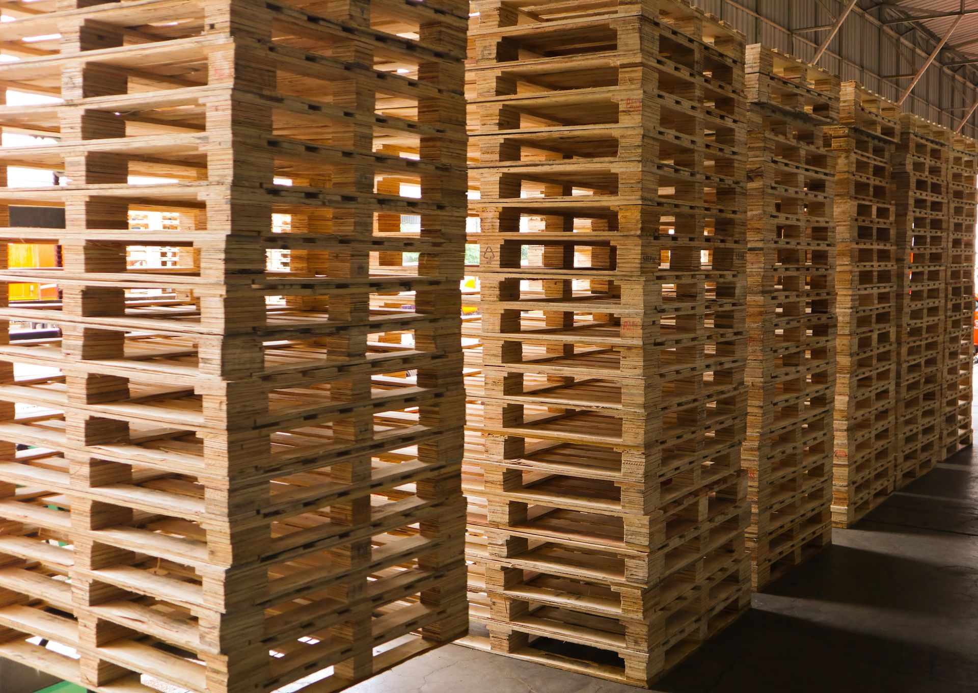 Hautes piles de palettes qui projettent des ombres.