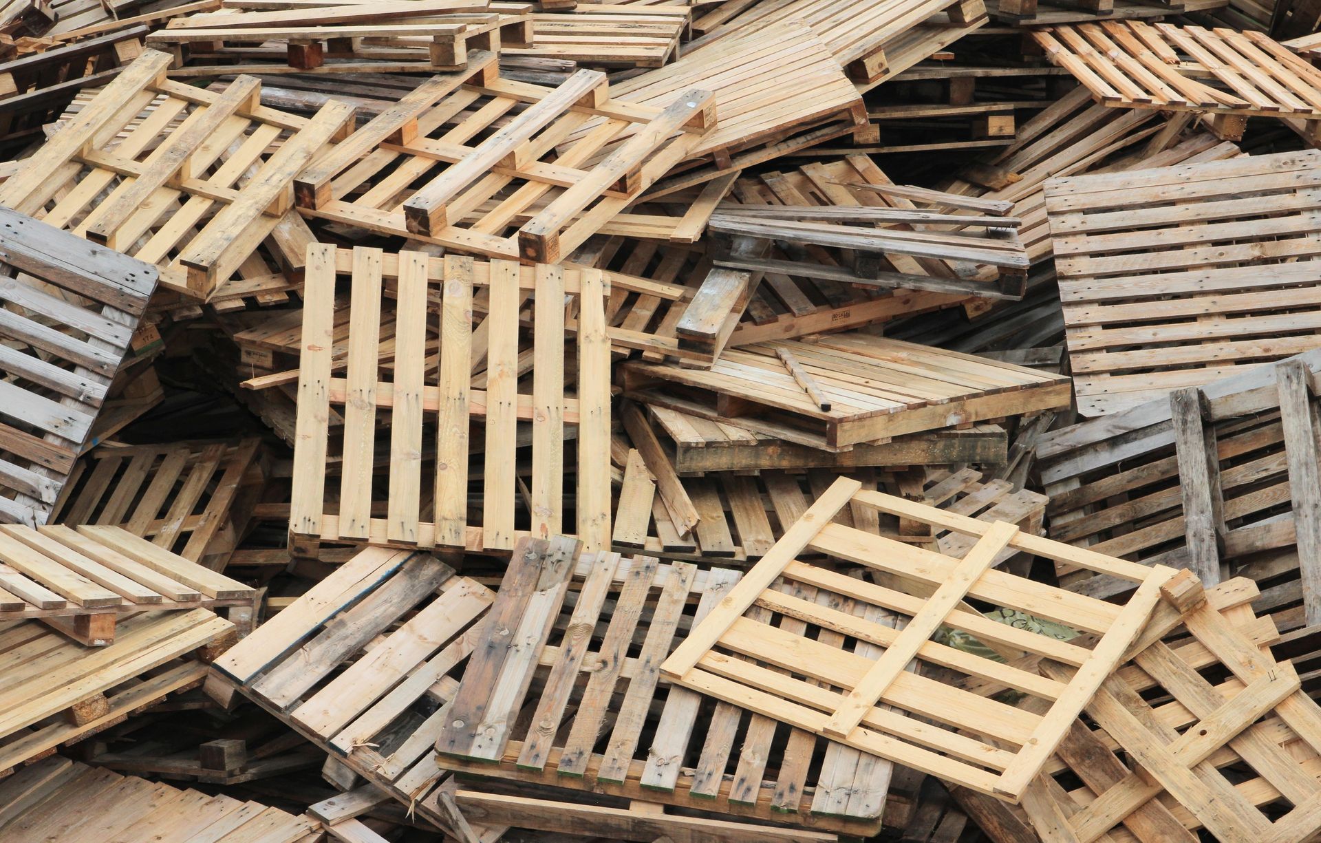 Palettes en bois usagées empilées en vrac.