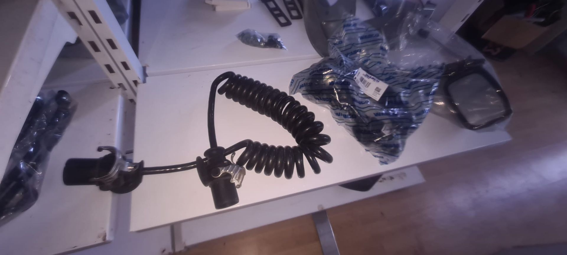 Un cable enrollado se encuentra sobre una mesa blanca.