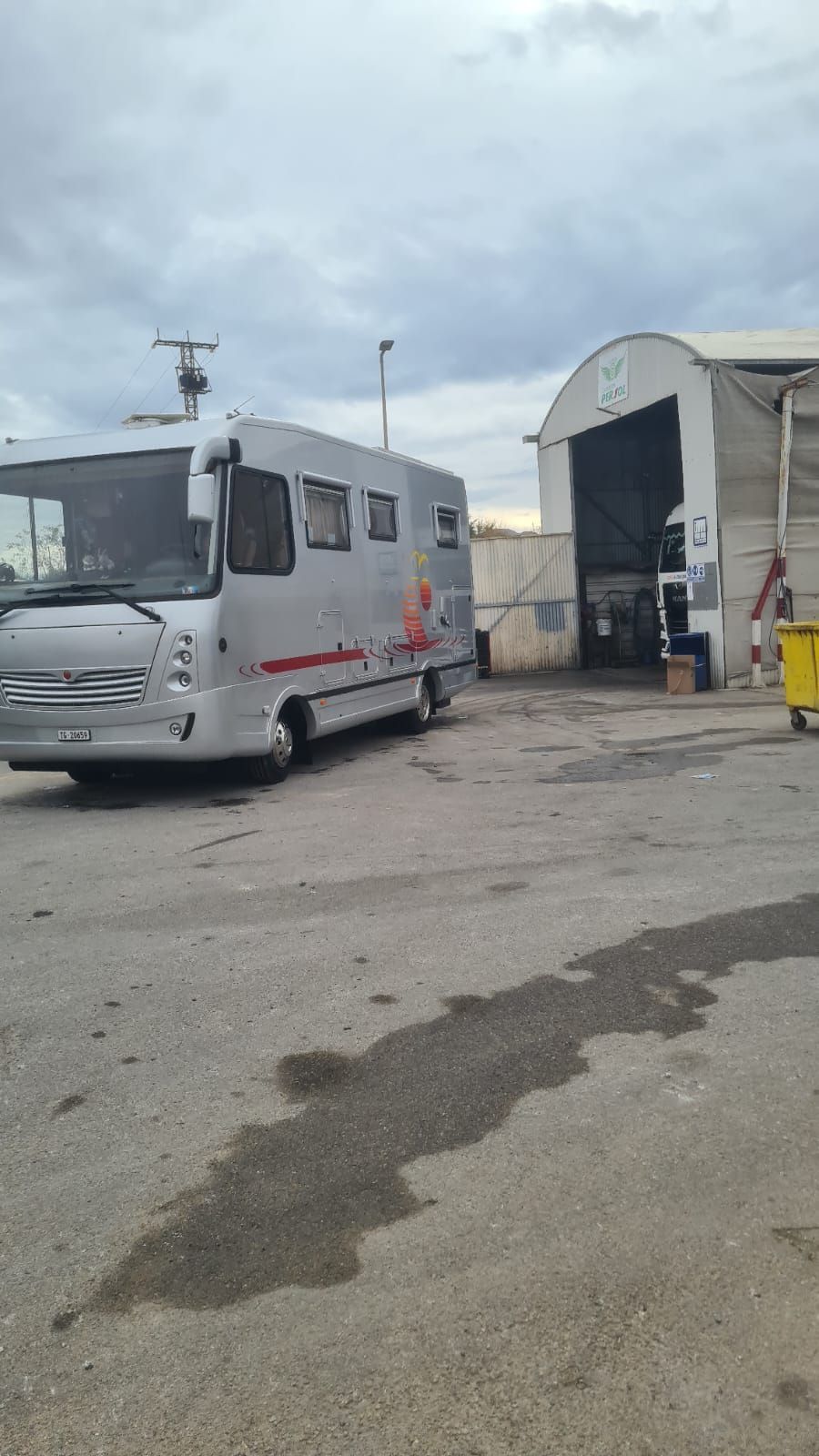 Un estacionamiento vacío con un lavado de autos al fondo.
