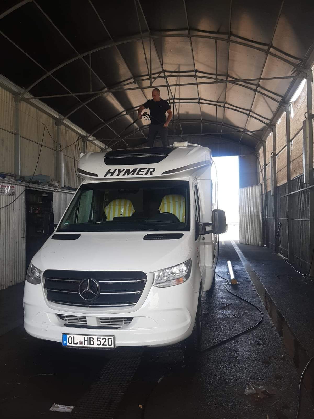 Un camión blanco está estacionado en un estacionamiento al lado de un edificio.