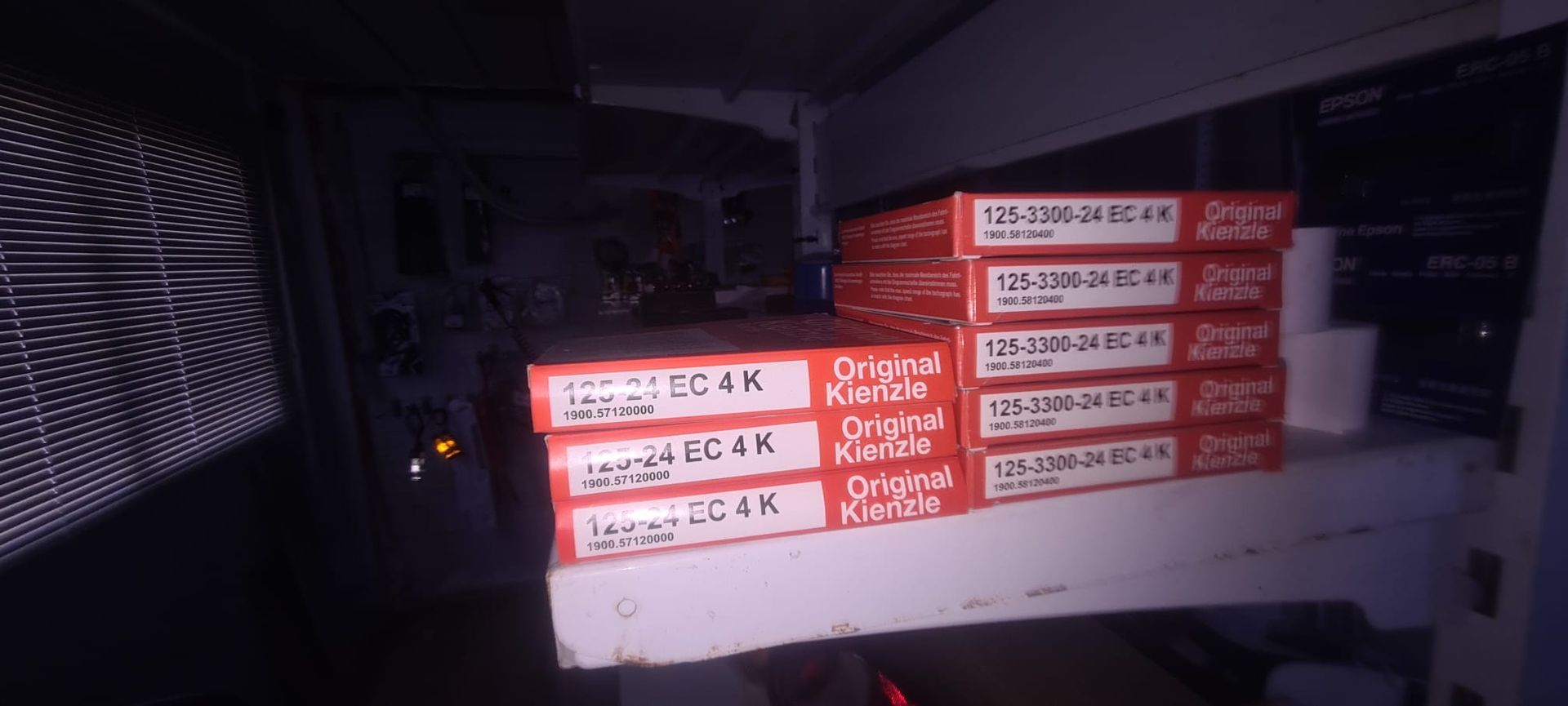 Una pila de cajas de pizza colocadas una encima de otra en un estante.