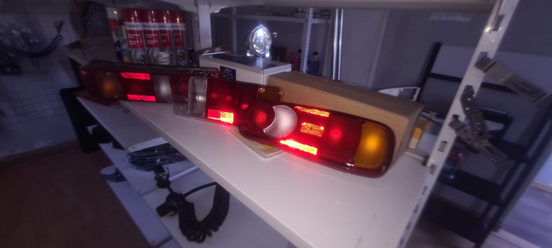 Un montón de luces están colocadas en un estante en una habitación oscura.