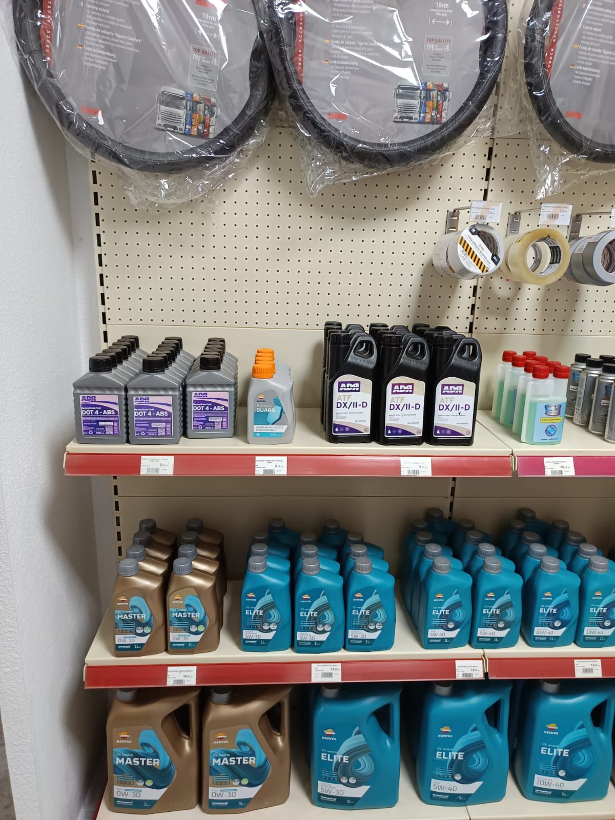 Un estante lleno de muchas botellas de aceite y neumáticos.