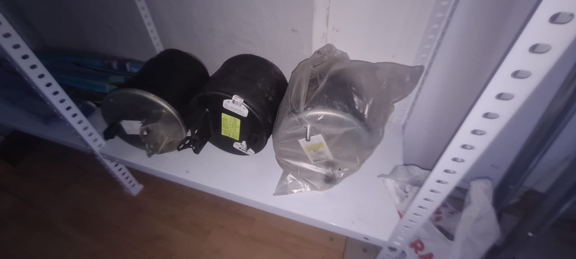 Hay tres cilindros sobre un estante blanco.