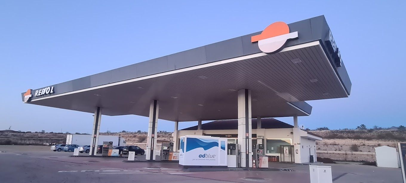 Una gasolinera con coches aparcados delante