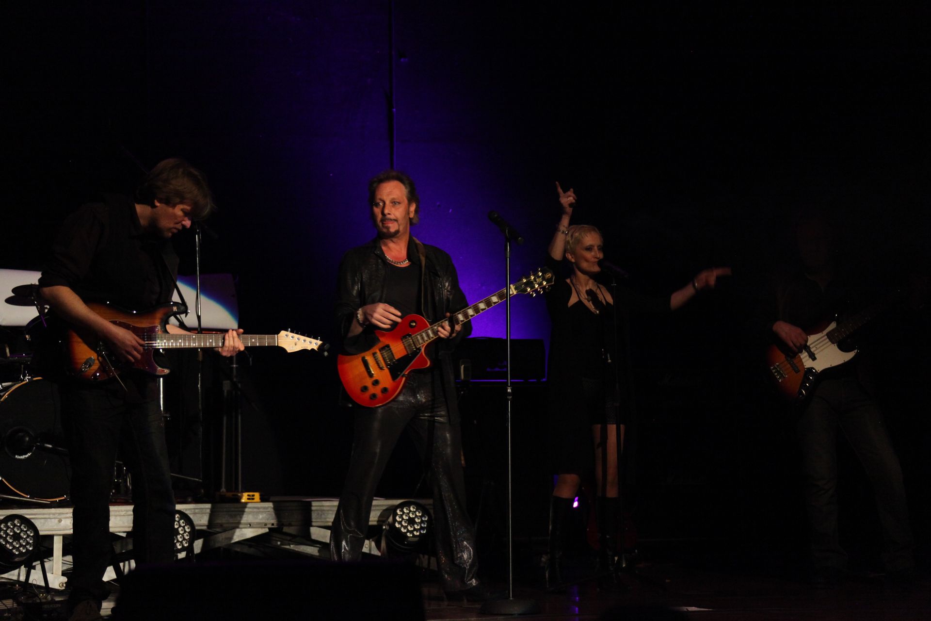 Groupe jouant sur scène, JOHNNY DEMS avec sa guitare au centre et ses musiciens.