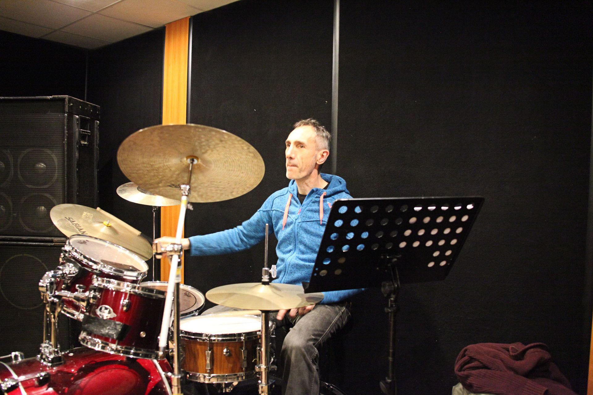 Un batteur joue de la batterie dans un studio d'enregistrement.