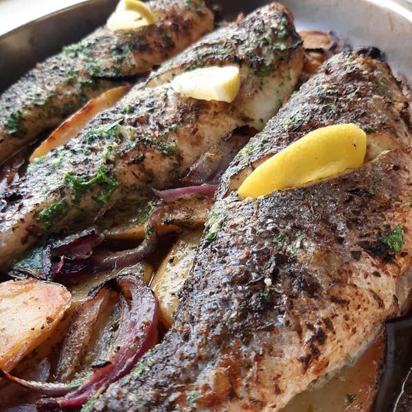 Un primer plano de un plato de comida con pescado y patatas.