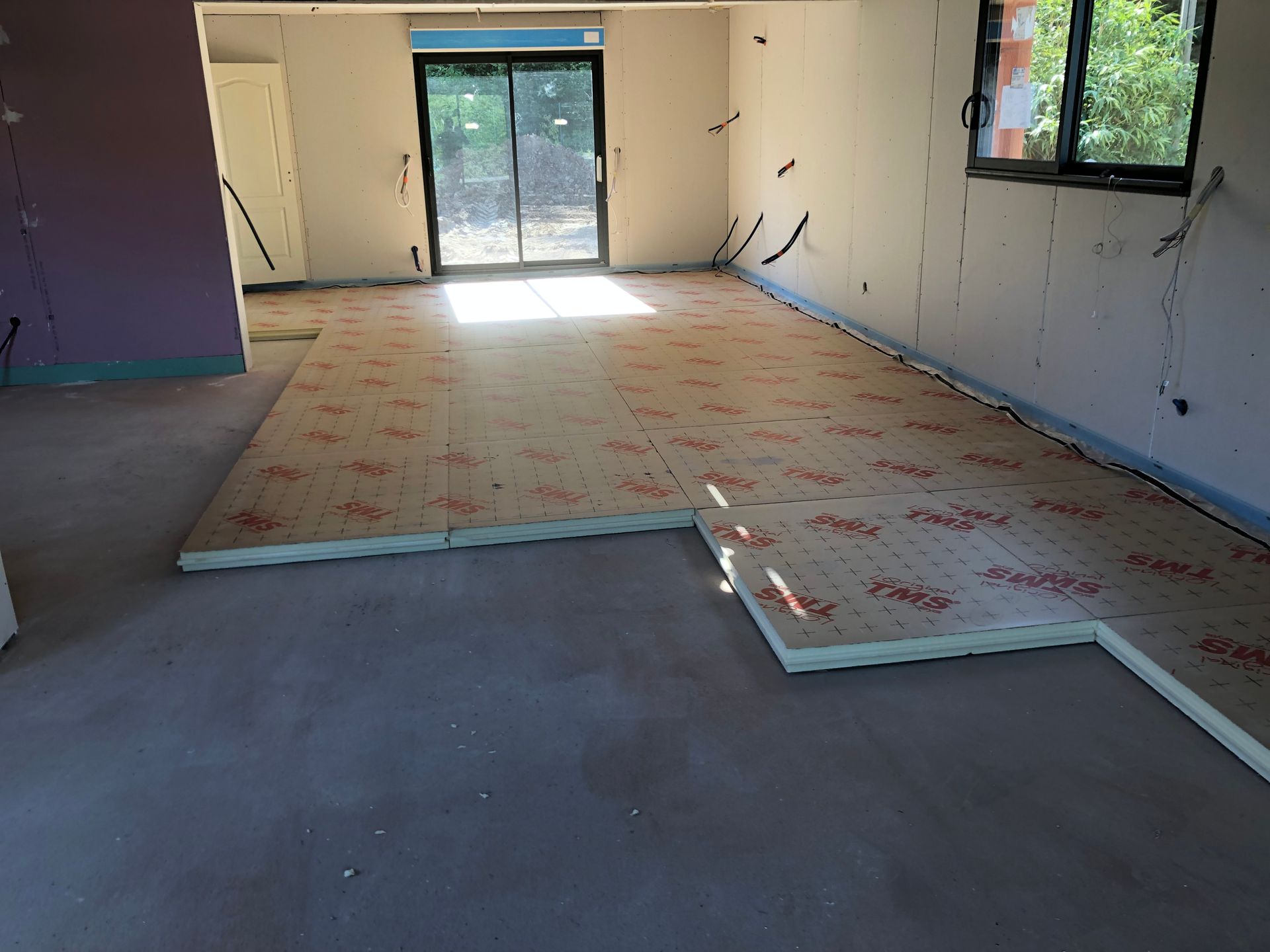 Personne posant des tuiles gris foncé sur un toit.