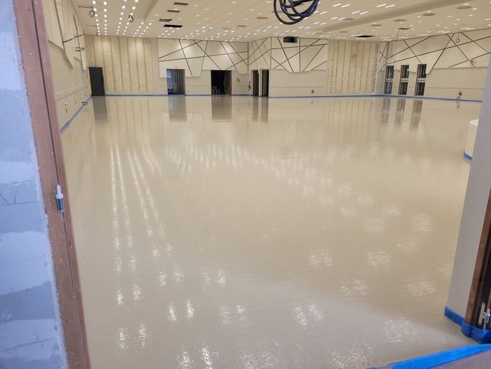 Studio vide avec miroirs, sol beige poli et éclairage lumineux au plafond