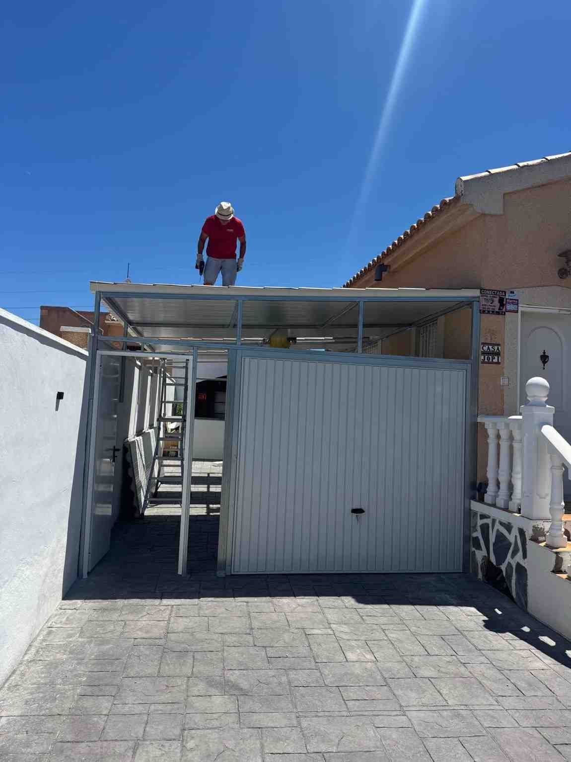 Una persona de pie en la azotea de un edificio con acceso restringido, bajo un cielo azul brillante.